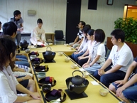 A picture of the participants receiving an explanation about tea ceremony from the instructor