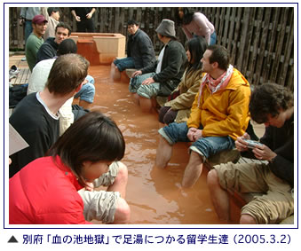 別府「血の池地獄」で足湯につかる留学生達の写真。2005年3月2日