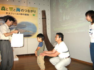 家族を代表して男の子への記念品贈呈の写真