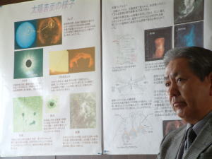 壁に貼られた研究についての説明と石浦技術専門職員