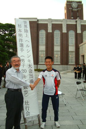 握手を交わす尾池総長（左）と杉本さん（右）