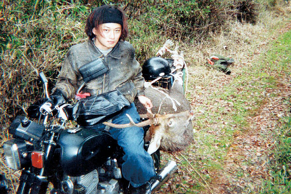 バイクで獲物を運搬する千松さん