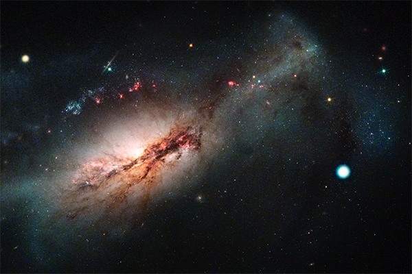 電子捕獲型超新星2018zd（右の明るい点）。左には超新星の発生した銀河NGC 2146が写っている。ラスクンブレス天文台（LCO）により取得された超新星2018zdの画像とハッブル宇宙望遠鏡画像の合成画像（LCO/NASA/STScI/J. DePasquale）